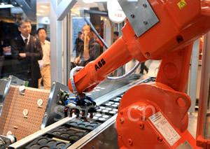 参观者正在观看ABB生产的机器人。